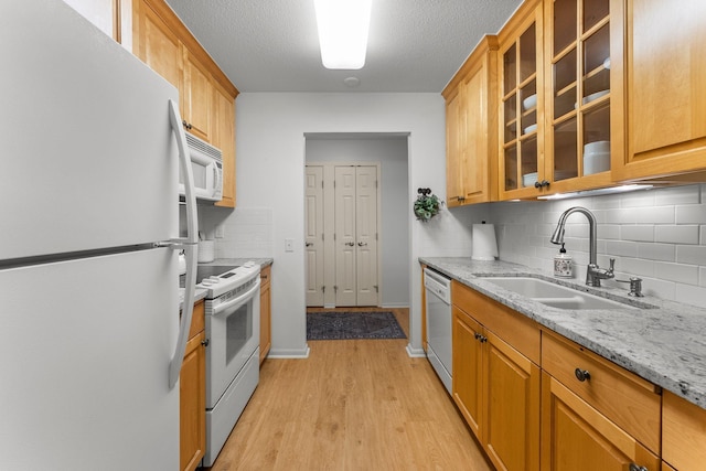 4380 Brookside Ct Unit 103, Edina, MN 55436 - kitchen with white appliances, light wood-type flooring, decorative backsplash, glass insert cabinets, and light stone countertops