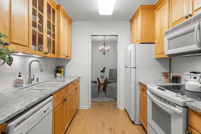 4380 Brookside Ct Unit 103, Edina, MN 55436 - kitchen featuring white appliances, light wood-style flooring, backsplash, light stone countertops, and a chandelier