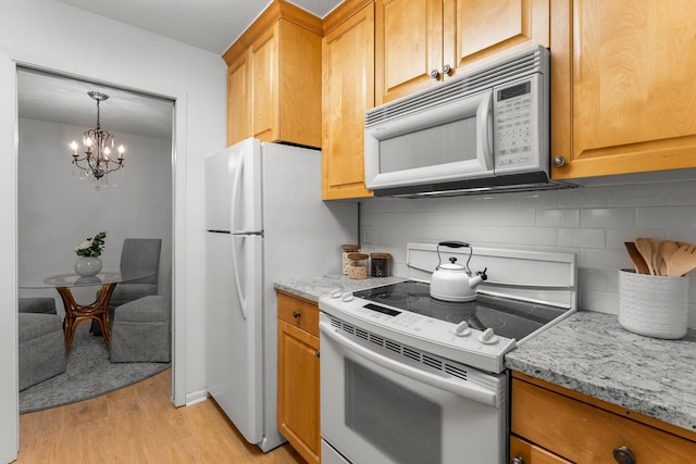 4380 Brookside Ct Unit 103, Edina, MN 55436 - kitchen with white appliances, a chandelier, light wood-type flooring, backsplash, and light stone counters