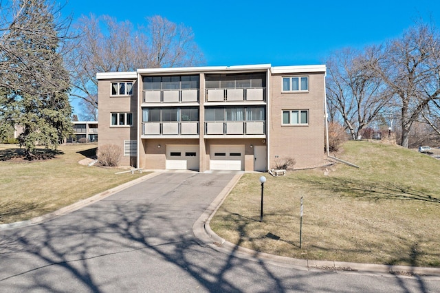 4380 Brookside Ct Unit 103, Edina, MN 55436 - back of property with a garage, asphalt driveway, a yard, stucco siding, and a balcony