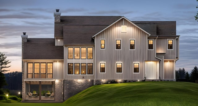 3271 Casco Cir, Orono, MN 55391 - back of house at dusk with a chimney, a yard, a shingled roof, and a patio