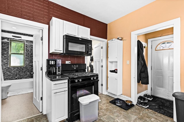 702 11th St, Duluth, MN 55805 - kitchen with black appliances, white cabinetry, dark countertops, and decorative backsplash