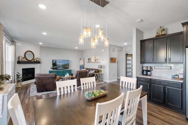 1126 Stonebridge Path, Jordan, MN 55352 - dining area featuring dark wood-style flooring, recessed lighting, a fireplace, and a chandelier
