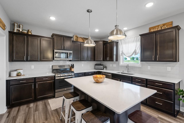 1126 Stonebridge Path, Jordan, MN 55352 - kitchen featuring stainless steel appliances, a breakfast bar area, dark brown cabinets, dark wood-style floors, and recessed lighting