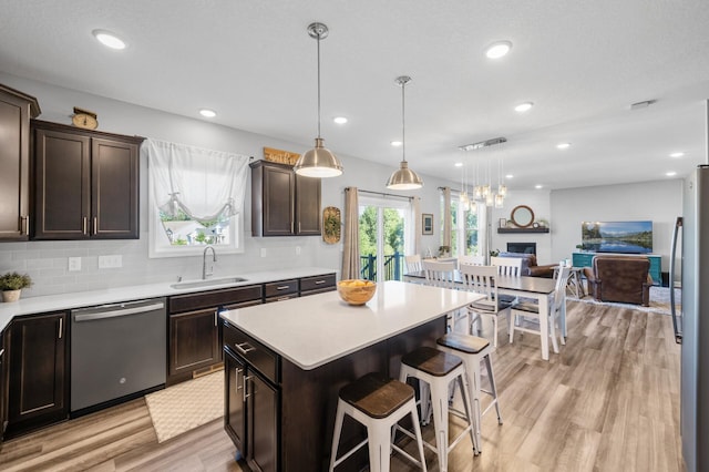 1126 Stonebridge Path, Jordan, MN 55352 - kitchen with appliances with stainless steel finishes, dark brown cabinetry, light wood-style floors, open floor plan, and recessed lighting
