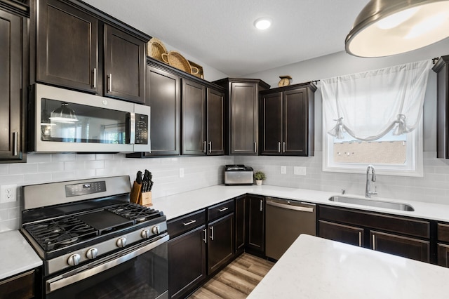 1126 Stonebridge Path, Jordan, MN 55352 - kitchen featuring appliances with stainless steel finishes, light countertops, tasteful backsplash, light wood-type flooring, and dark brown cabinetry