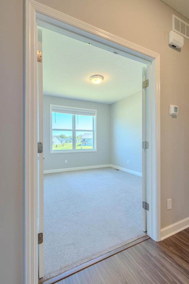 8251 62nd St, Bay South, Cottage Grove, MN 55016 - carpeted empty room featuring baseboards and wood finished floors