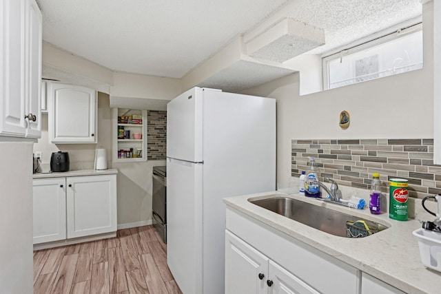 3825 2 1/2 St NE, Columbia Heights, MN 55421 - kitchen with freestanding refrigerator, range, white cabinetry, tasteful backsplash, and light stone countertops