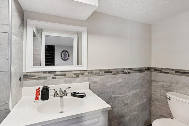 3825 2 1/2 St NE, Columbia Heights, MN 55421 - bathroom with tile walls, vanity, a textured ceiling, and wainscoting