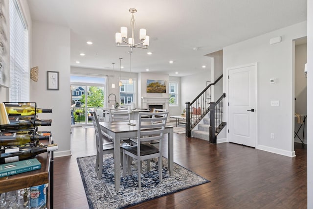 4297 Corn Silk Ln, Woodbury, MN 55129 - dining space with stairway, dark wood-type flooring, a fireplace, a chandelier, and recessed lighting