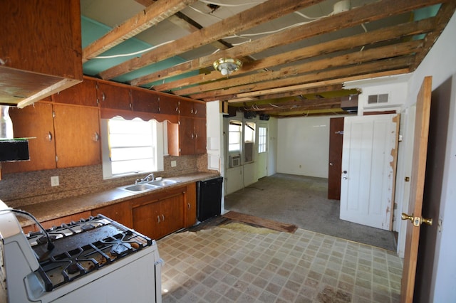 506 3rd Ave NW, Dodge Center, MN 55927 - kitchen featuring white gas range, dishwasher, brown cabinets, backsplash, and light countertops