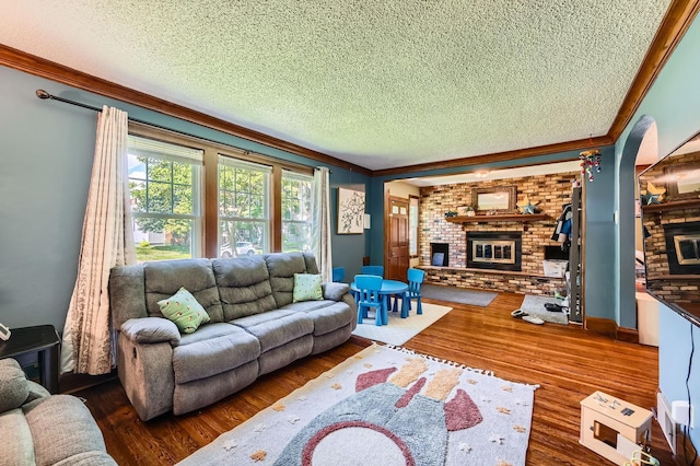 1268 Stanford Ave, Saint Paul, MN 55105 - living room with a brick fireplace, a textured ceiling, ornamental molding, and wood finished floors