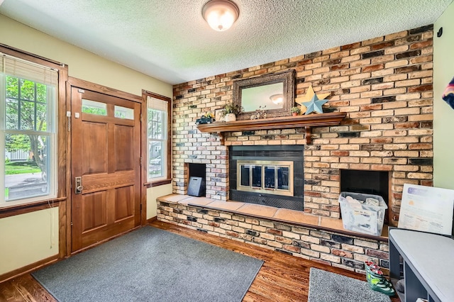 1268 Stanford Ave, Saint Paul, MN 55105 - foyer entrance with a fireplace, a textured ceiling, and wood finished floors