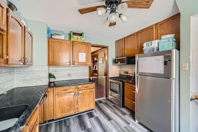 1268 Stanford Ave, Saint Paul, MN 55105 - kitchen with appliances with stainless steel finishes, ceiling fan, wood finished floors, brown cabinets, and decorative backsplash