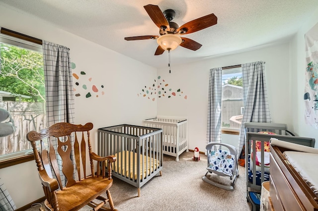 1268 Stanford Ave, Saint Paul, MN 55105 - bedroom featuring a crib, carpet floors, a textured ceiling, and ceiling fan