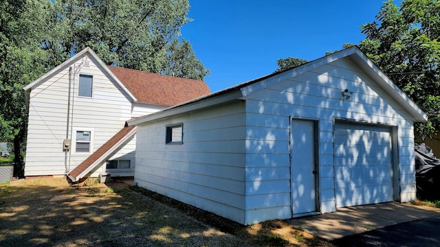 315 Woodworth St, Elmwood, WI 54740 - view of side of home with a detached garage, an outbuilding, and roof with shingles