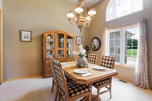 2064 141st Ln NE, Ham Lake, MN 55304 - dining space featuring a high ceiling, a chandelier, healthy amount of natural light, and light carpet