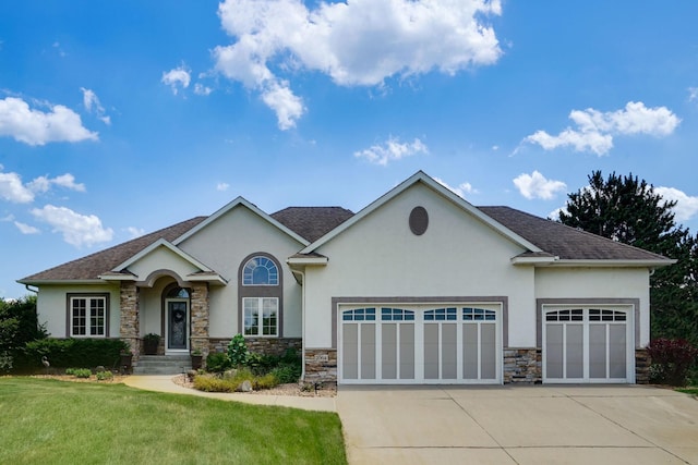 2064 141st Ln NE, Ham Lake, MN 55304 - view of front of property with an attached garage, stucco siding, stone siding, and driveway