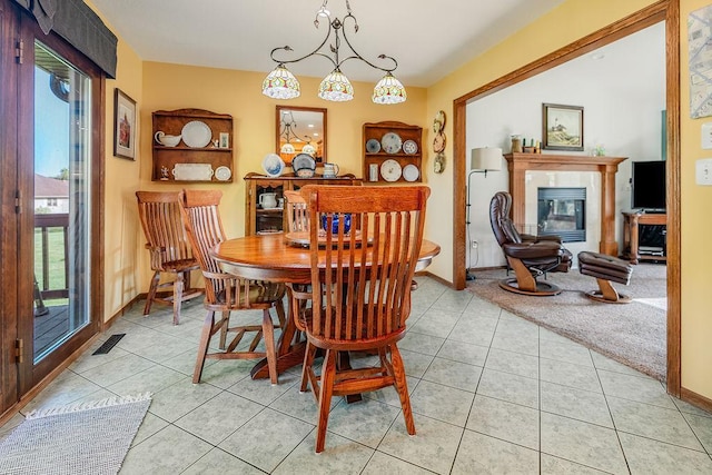 2711 Cedar Ave, Holmen, WI 54636 - dining room featuring light tile patterned floors, healthy amount of natural light, a tiled fireplace, and a chandelier