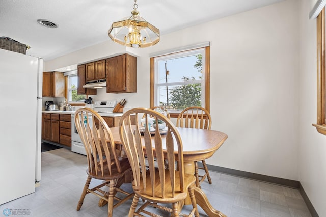 426 3rd Ave E, West Fargo, ND 58078 - dining space featuring light floors, healthy amount of natural light, and a chandelier