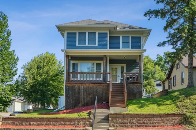 1661 Bush Ave, Saint Paul, MN 55106 - traditional style home with stairway, a front yard, covered porch, and a shingled roof