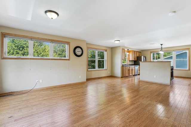 1661 Bush Ave, Saint Paul, MN 55106 - unfurnished living room with healthy amount of natural light and light wood-style floors
