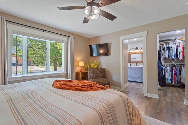 905 Sellards Dr, Dassel, MN 55325 - bedroom with wood finished floors, a spacious closet, ensuite bathroom, ceiling fan, and a textured ceiling