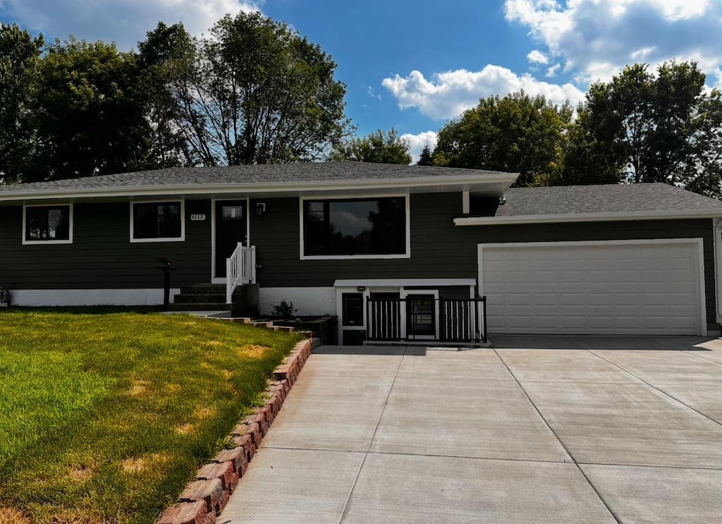 6113 Scott Ave N, Brooklyn Center, MN 55429 - view of front of property featuring a garage, concrete driveway, a front lawn, and roof with shingles