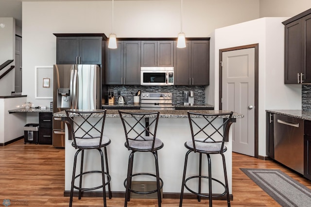 3137 6th St E, West Fargo, ND 58078 - kitchen featuring appliances with stainless steel finishes, light wood-style floors, a breakfast bar, and decorative backsplash