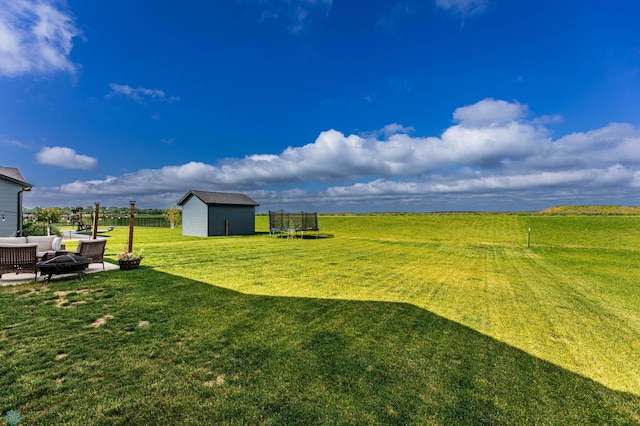 8827 Northern Lights Ave, Horace, ND 58047 - view of green lawn featuring a trampoline, a storage unit, and an outdoor living space with a fire pit