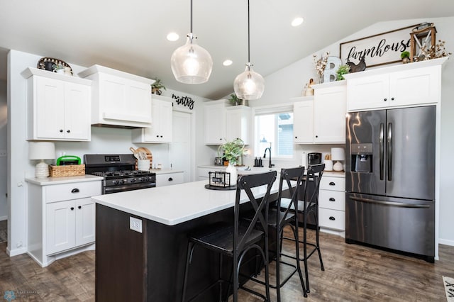 8827 Northern Lights Ave, Horace, ND 58047 - kitchen featuring stainless steel fridge, gas stove, lofted ceiling, dark wood finished floors, and light countertops