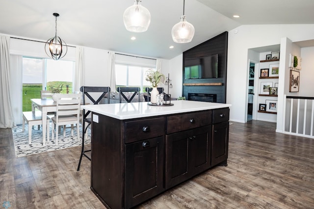 8827 Northern Lights Ave, Horace, ND 58047 - kitchen featuring vaulted ceiling, dark wood finished floors, a large fireplace, light countertops, and a kitchen bar