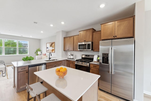 7419 E Ramsey Pkwy NW, Ramsey, MN 55303 - kitchen with appliances with stainless steel finishes, a peninsula, light wood-style flooring, tasteful backsplash, and recessed lighting
