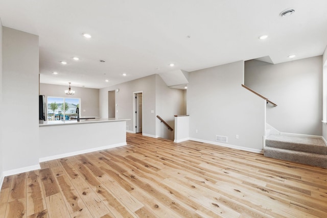 7419 E Ramsey Pkwy NW, Ramsey, MN 55303 - unfurnished living room with light wood finished floors, recessed lighting, and a chandelier