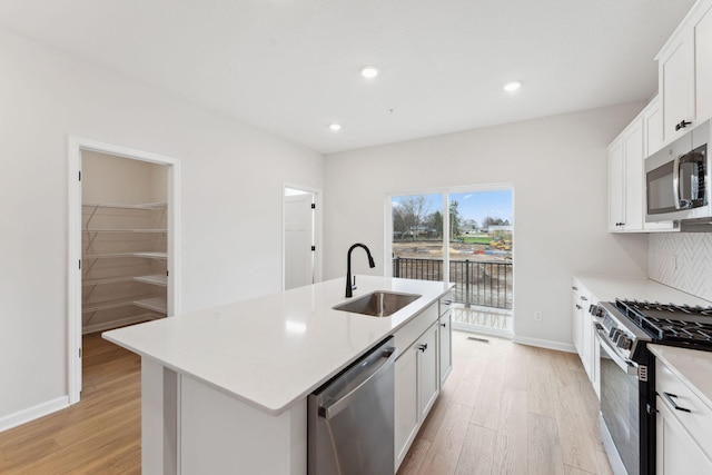 7415 E Ramsey Pkwy NW, Ramsey, MN 55303 - kitchen featuring stainless steel appliances, light wood finished floors, light countertops, a kitchen island with sink, and recessed lighting