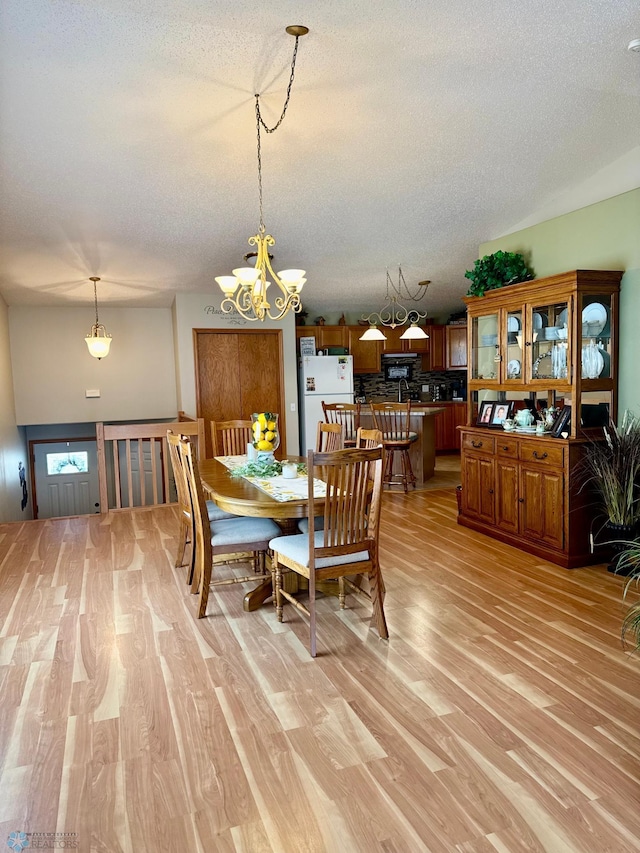 1815 49th St S, Fargo, ND 58103 - dining area featuring a textured ceiling, light wood-style floors, and a chandelier