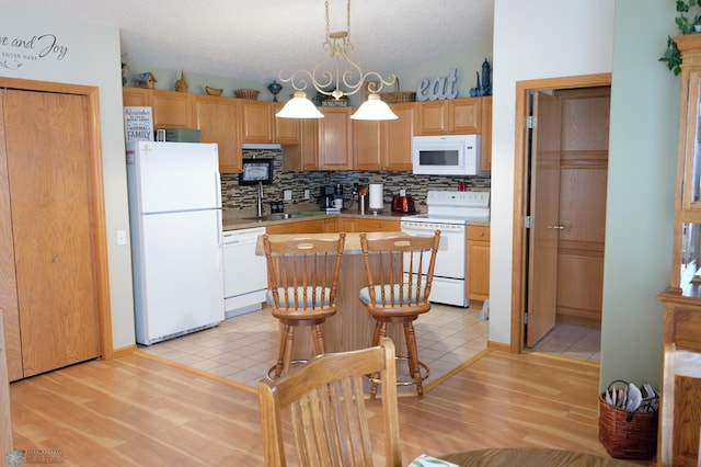 1815 49th St S, Fargo, ND 58103 - kitchen featuring white appliances, tasteful backsplash, light countertops, and light wood-style floors