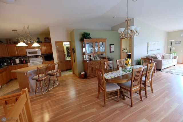 1815 49th St S, Fargo, ND 58103 - dining space with light wood-style flooring, lofted ceiling, and a chandelier