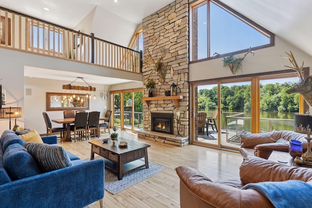 708 Riverside Dr N, North Hudson, WI 54016 - living area with a high ceiling, plenty of natural light, a chandelier, hardwood / wood-style floors, and a stone fireplace