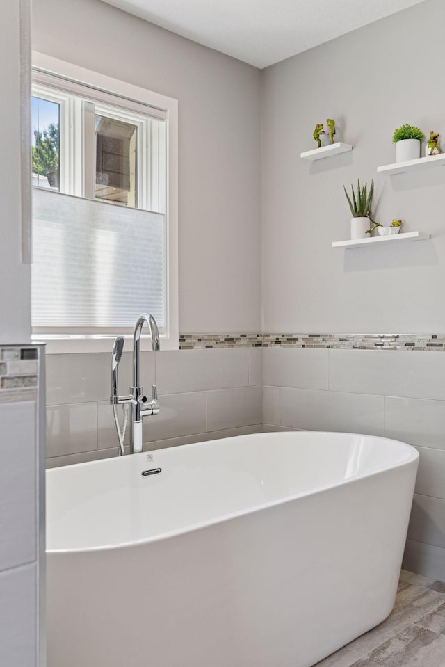 708 Riverside Dr N, North Hudson, WI 54016 - bathroom featuring tile walls, a soaking tub, and wainscoting