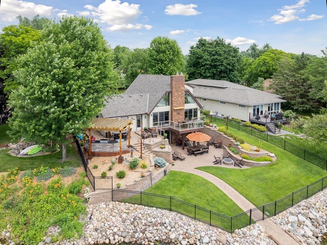 708 Riverside Dr N, North Hudson, WI 54016 - back of property with a pergola, a deck, a fenced backyard, a patio area, and an outdoor fire pit