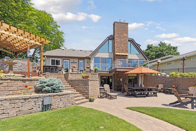 708 Riverside Dr N, North Hudson, WI 54016 - back of house with a patio area, a chimney, a balcony, and a pergola
