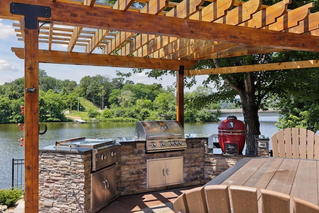 708 Riverside Dr N, North Hudson, WI 54016 - view of patio / terrace with a water view, an outdoor kitchen, a pergola, and view of scattered trees