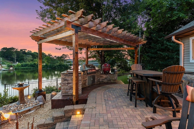 708 Riverside Dr N, North Hudson, WI 54016 - patio terrace at dusk with area for grilling, a water view, a pergola, and a patio