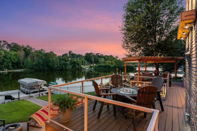 708 Riverside Dr N, North Hudson, WI 54016 - wooden terrace featuring an outdoor fire pit, a water view, a pergola, and a lawn