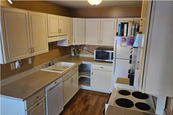 6201 Saint Croix Trl N Unit 115, Oak Park Heights, MN 55082 - kitchen with white appliances, dark wood finished floors, white cabinets, and light countertops