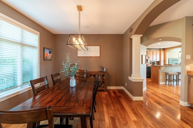 60515 235th St, Madison Lake, MN 56063 - dining room featuring decorative columns, healthy amount of natural light, light wood-type flooring, and arched walkways