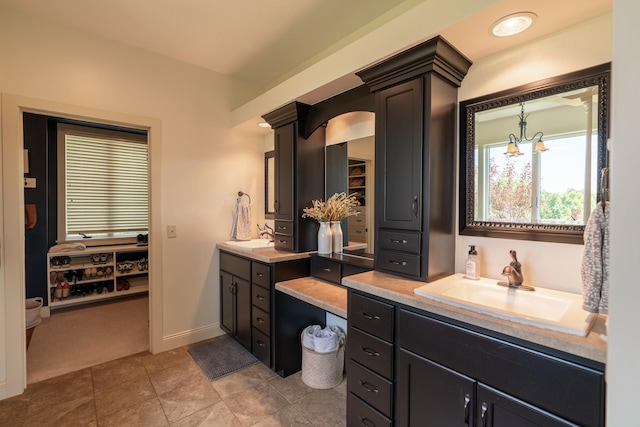 60515 235th St, Madison Lake, MN 56063 - bathroom with two vanities, a chandelier, and tile patterned floors
