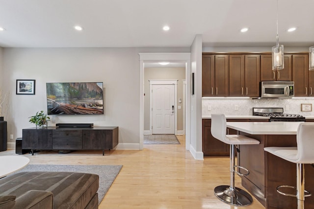 4312 France Ave S, Edina, MN 55410 - kitchen with stainless steel microwave, range, light countertops, tasteful backsplash, and open floor plan
