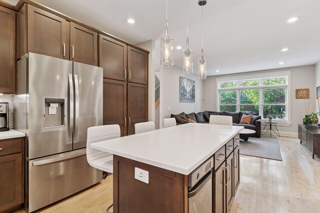 4312 France Ave S, Edina, MN 55410 - kitchen with stainless steel fridge, light wood finished floors, open floor plan, light countertops, and a kitchen island